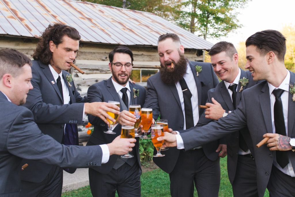 groom and groomsmen drinking beer and smoking cigars