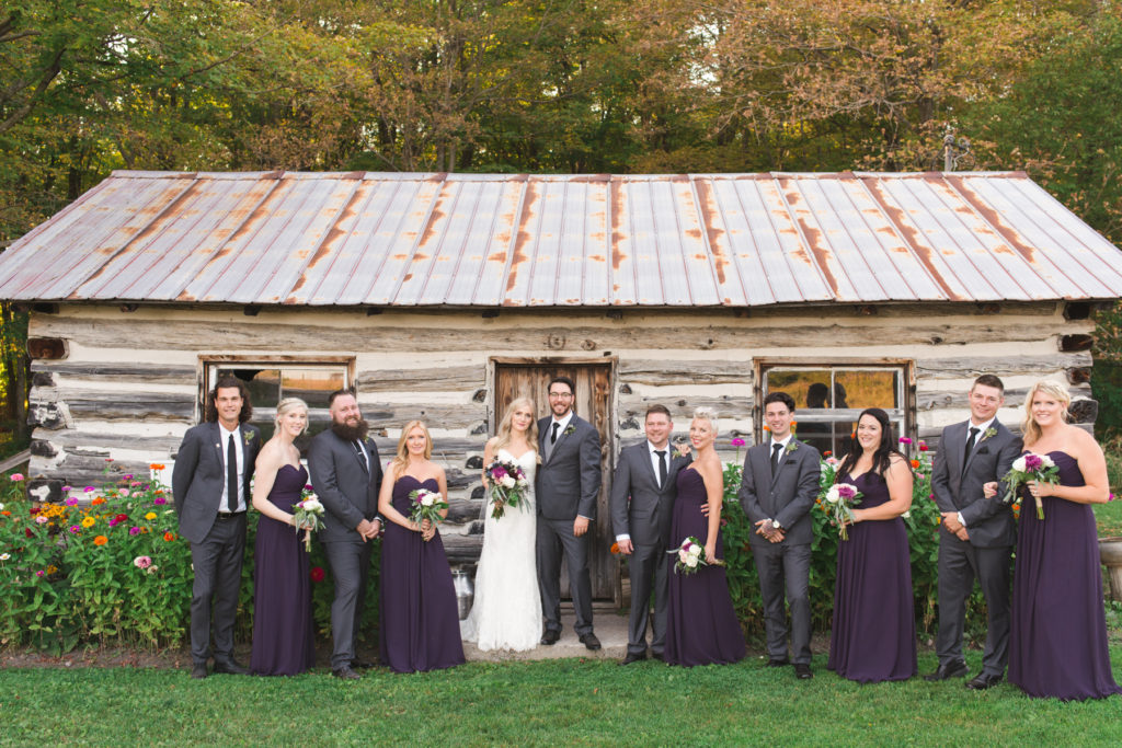 wedding party in purple in front of steamwhistle shack at temples