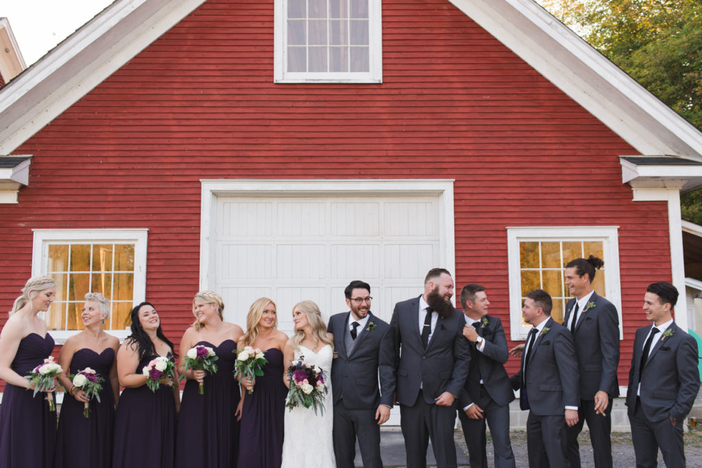 wedding party in front of red cabin