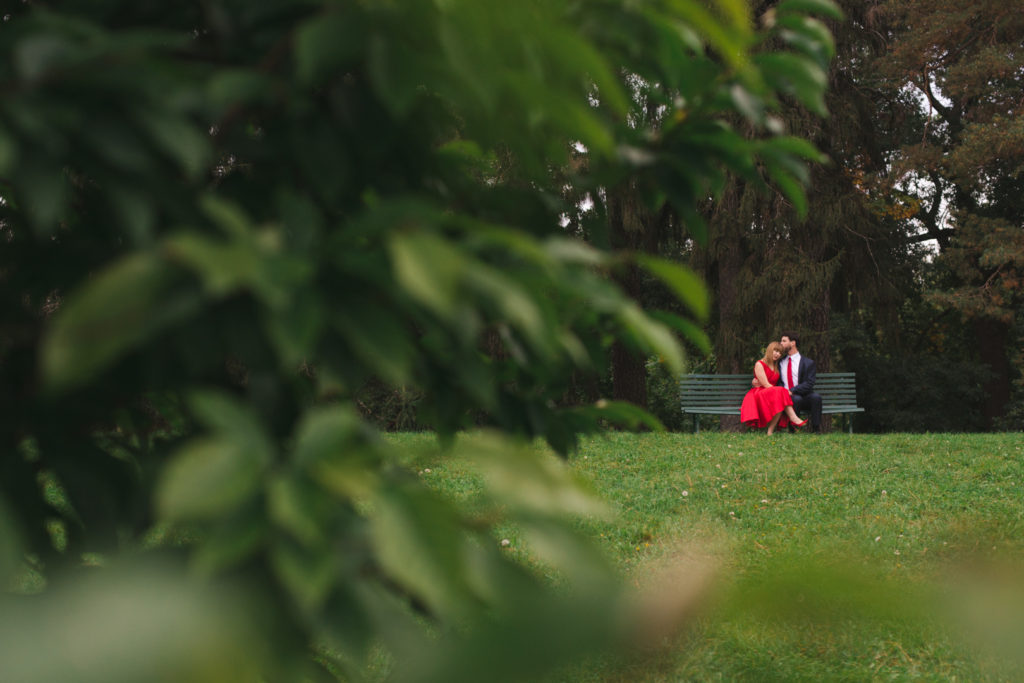 engaged couple sitting together on a park bench