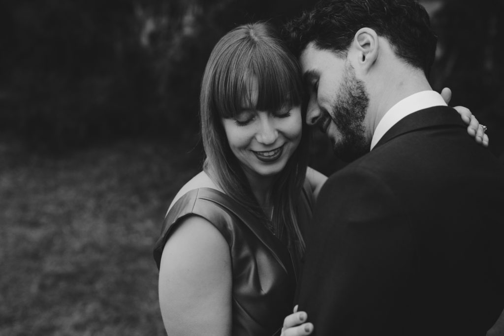 engaged couple cuddling in black and white