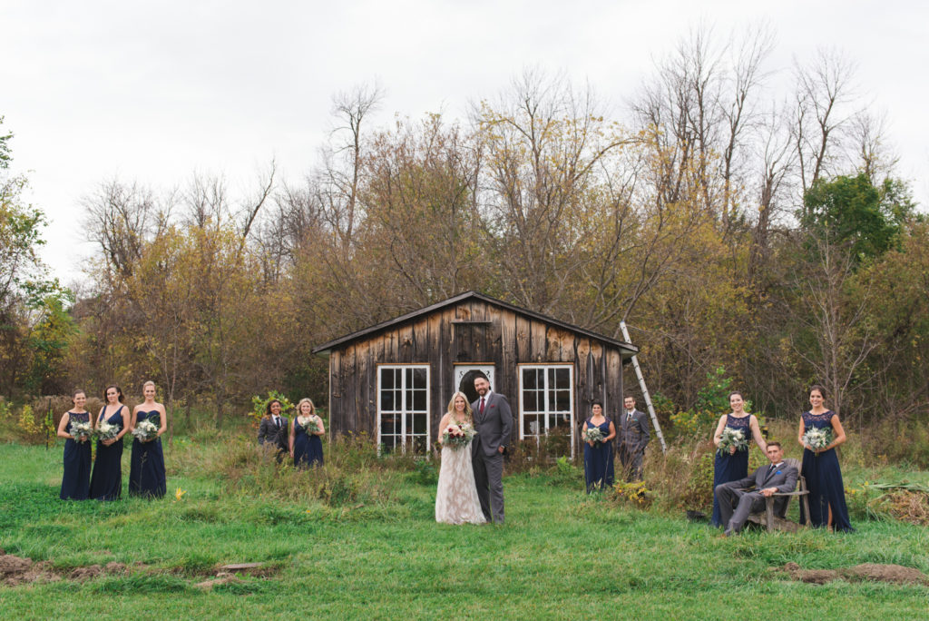 wedding party in front of rustic wooden cabin