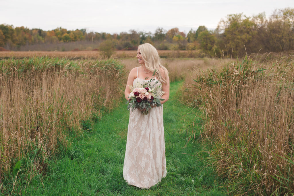 bride in champagne gown standing in fall fields at Strathmere