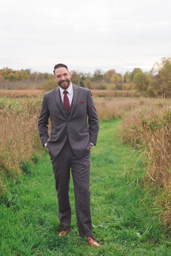 groom standing in fall fields of Strathmere