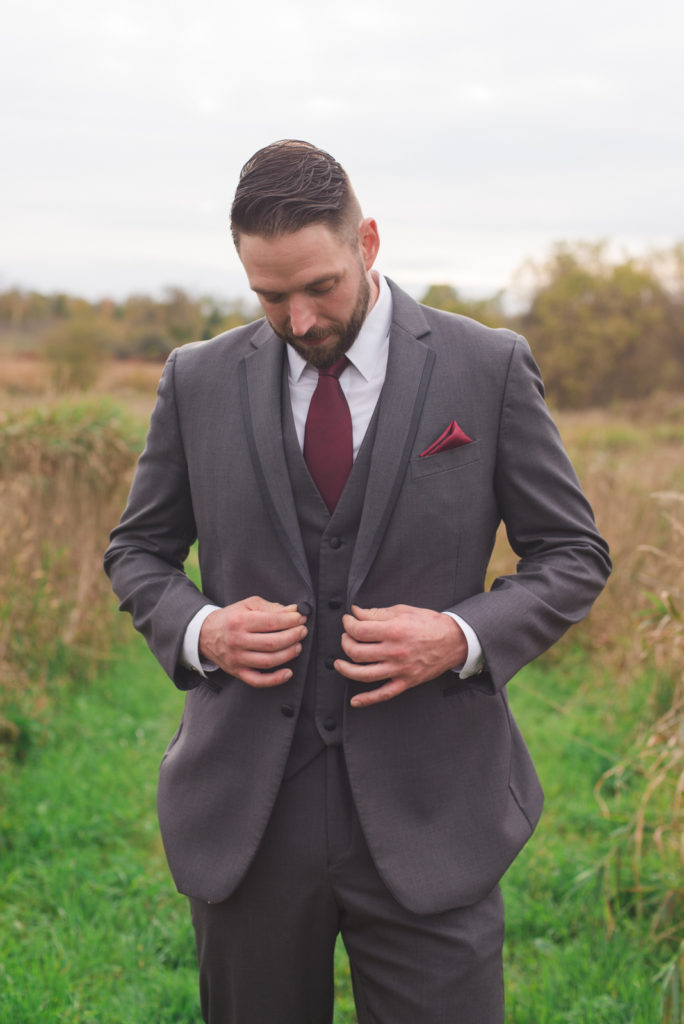 groom tying up his suit jacket