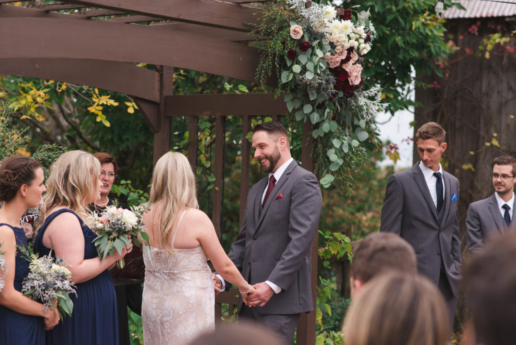 groom smiling at bride during wedding ceremony