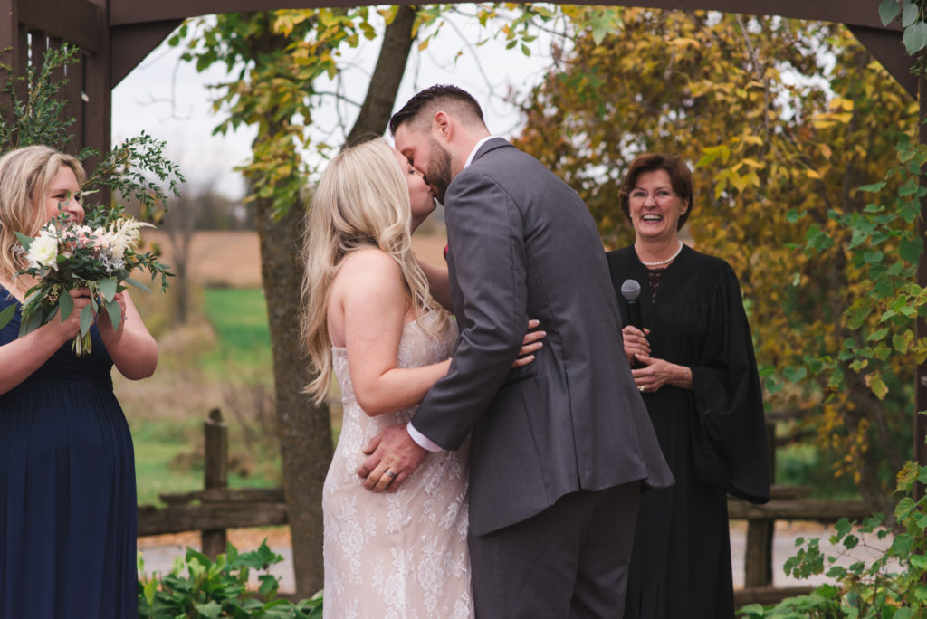 bride and groom first kiss during outdoor ceremony at the Lodge