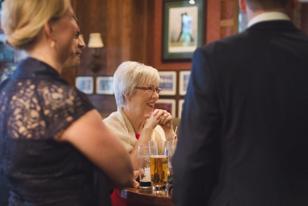 mother of the bride laughing at the pub with beer