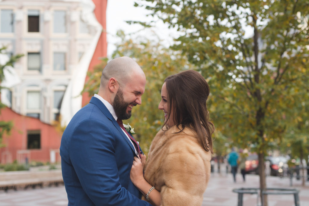 bride and groom laughing with each other in vintage fur