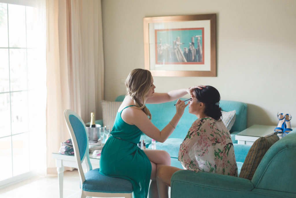 bride getting her makeup done in hotel suite