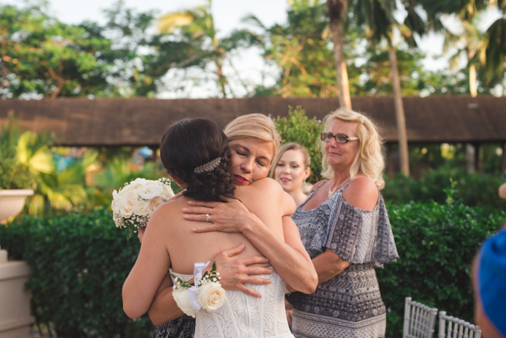 bride and her mom hugging at the end of the aisle