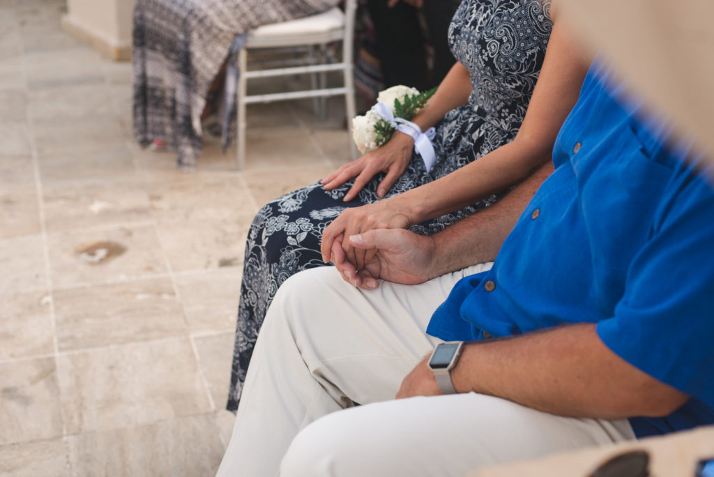bride's parents holding hands during ceremony