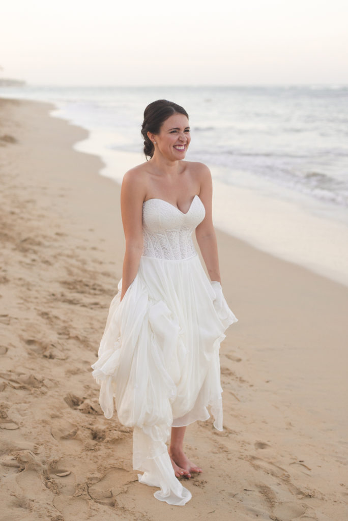 bride smiling standing on the beach at sunset