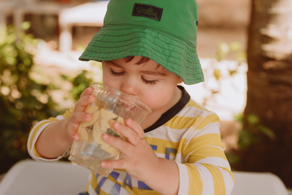 Little boy drinking from a plastic cup