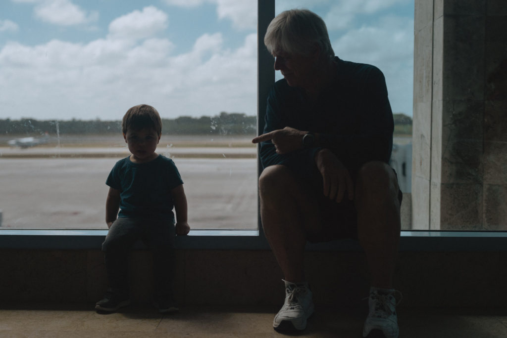 Little boy sitting with grandfather at the airport
