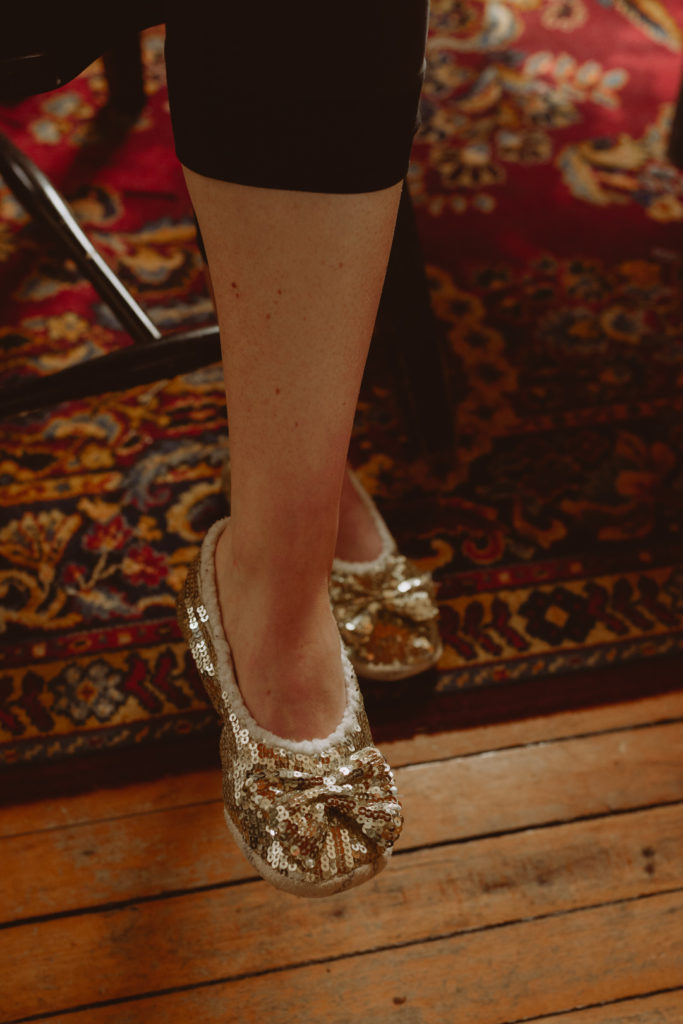 bride's sparkly slippers while she sits in a chair getting ready