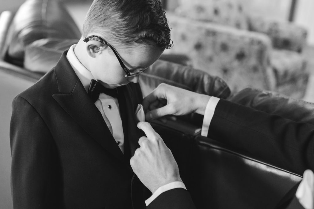 groom adjusting the ring bearer's pocket square