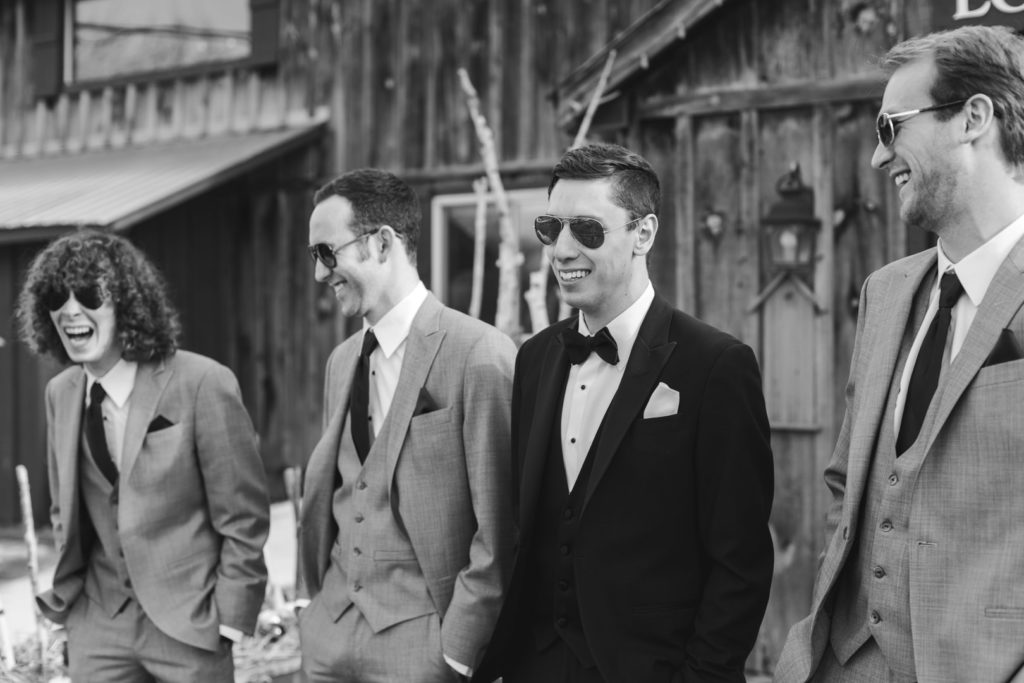 groomsmen laughing wearing aviator sunglasses