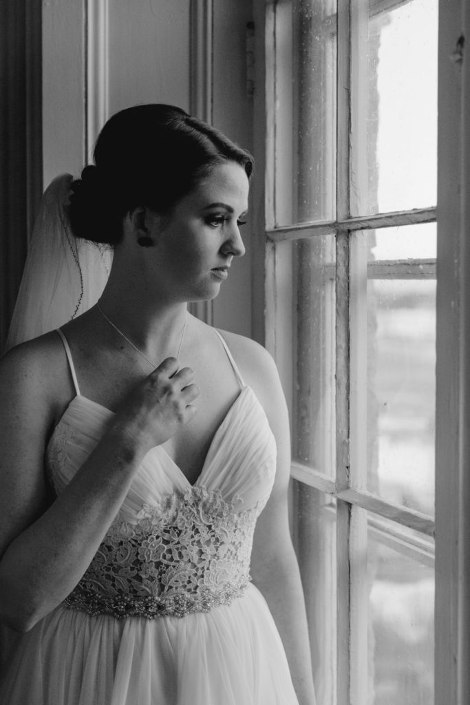 bride looking out the window playing with her necklace