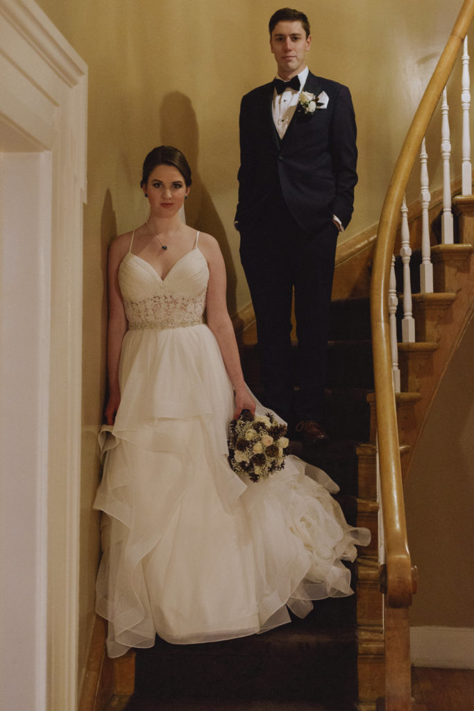 bride and groom standing on old spiral staircase