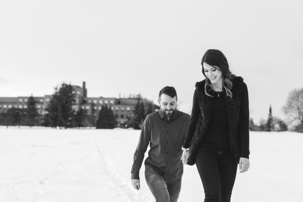 couple holding hands walking through the snow
