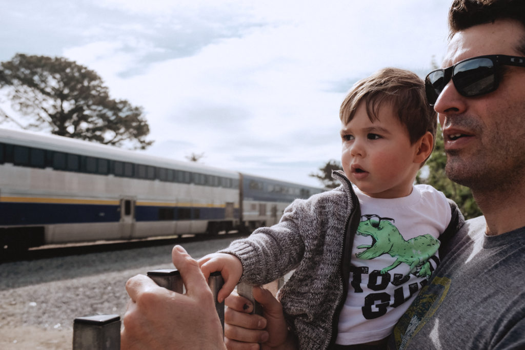 Father and son looking at train passing by in Carpenteria