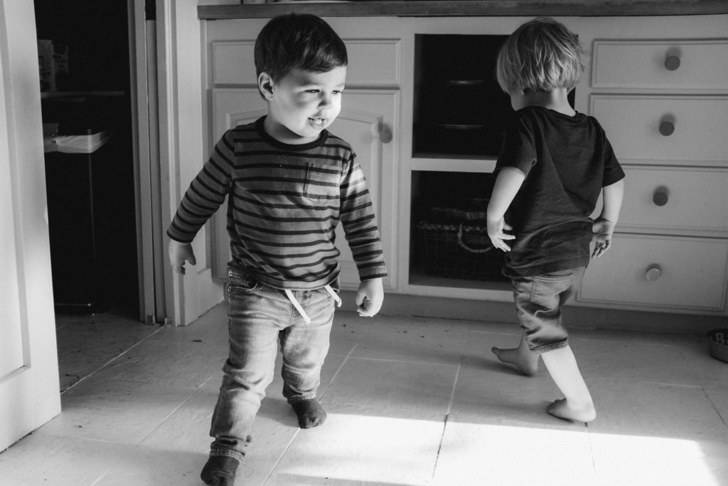 boys playing in the kitchen in black and white