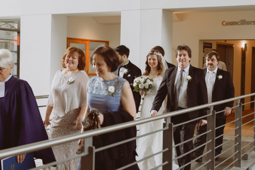 bride and groom and their families walking to the ceremony space