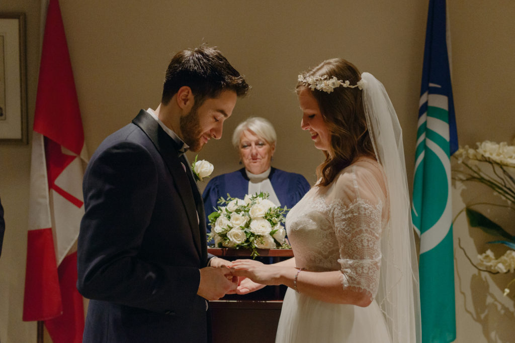 groom putting on the bride's wedding band