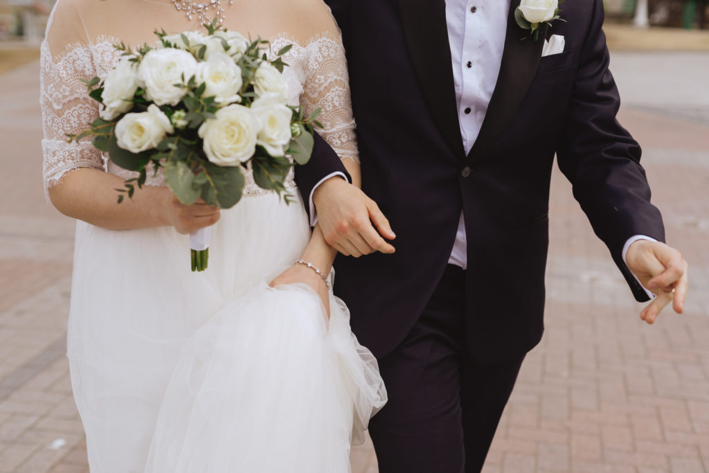 bride and groom walking together with arms interlaced