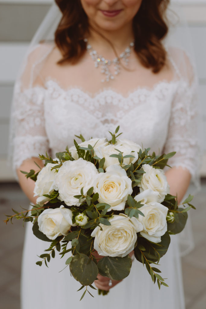 bride holding beautiful white and green floral bouquet