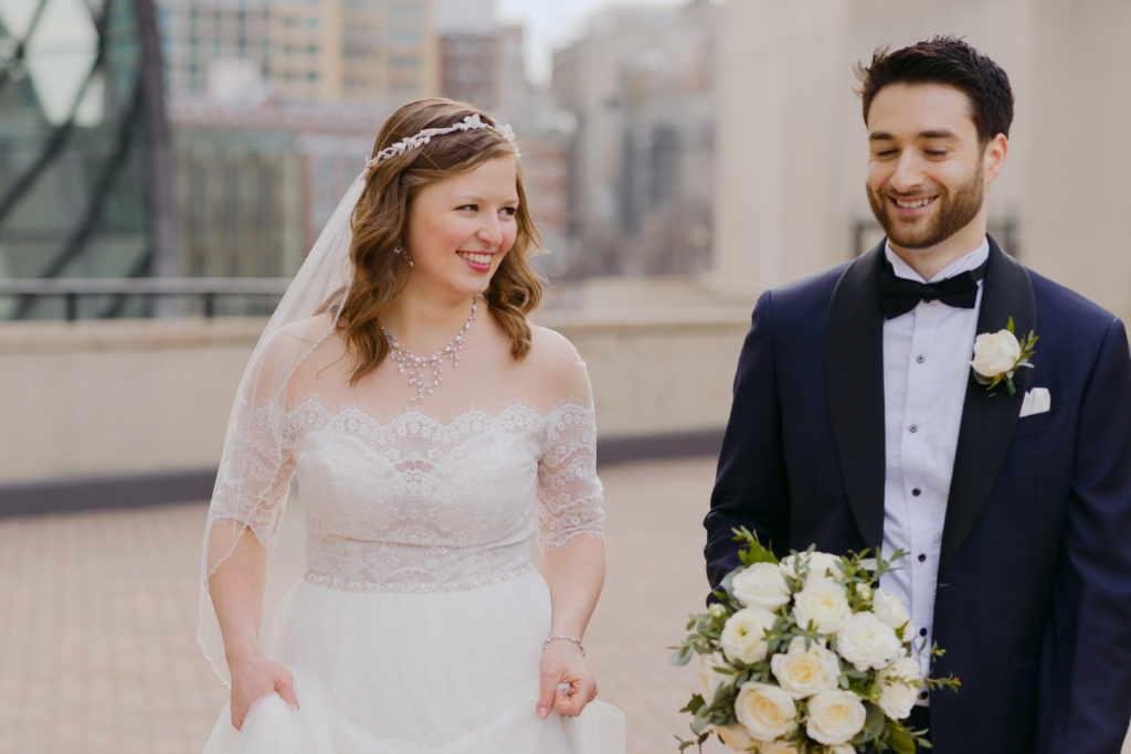 Bride and groom laughing as groom holds the bouquet