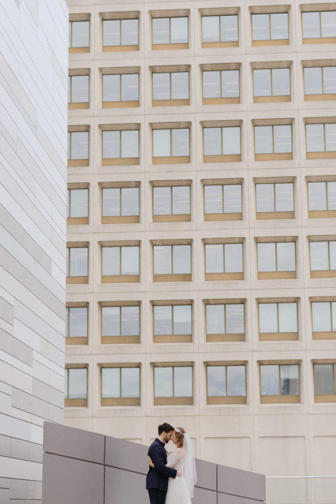 bride and groom cuddling together among architectural landscapes