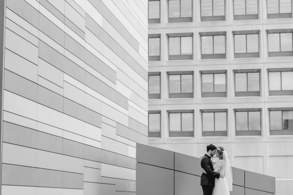 bride and groom cuddling with architecture