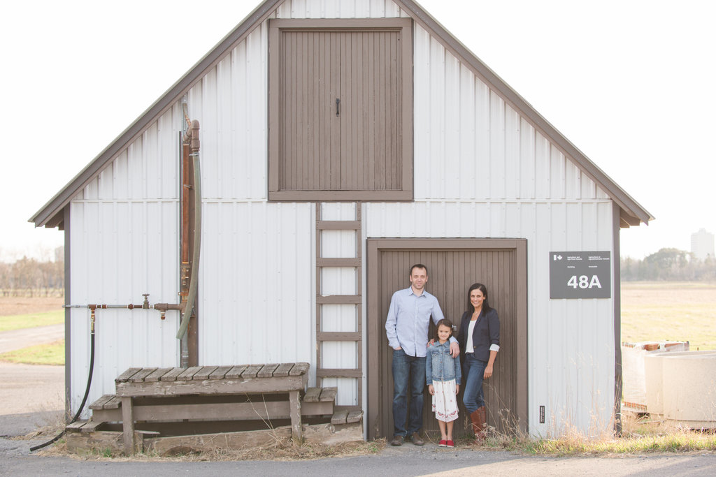 family standing in front of old barn