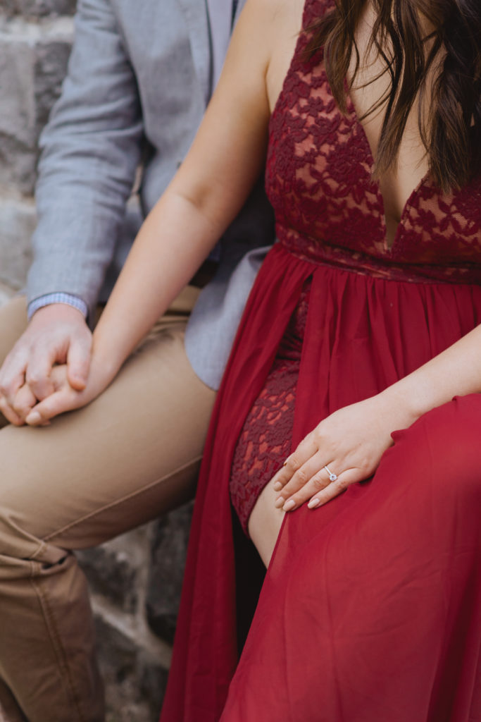 engaged couple holding hands while seated
