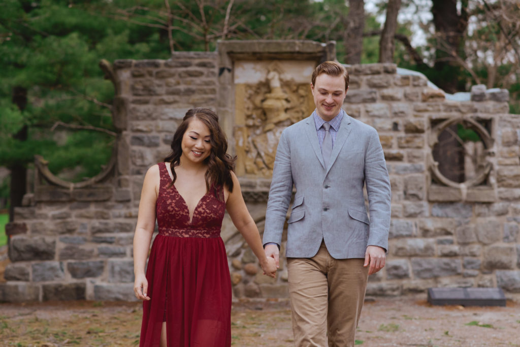 engaged couple holding hands walking around the ruins