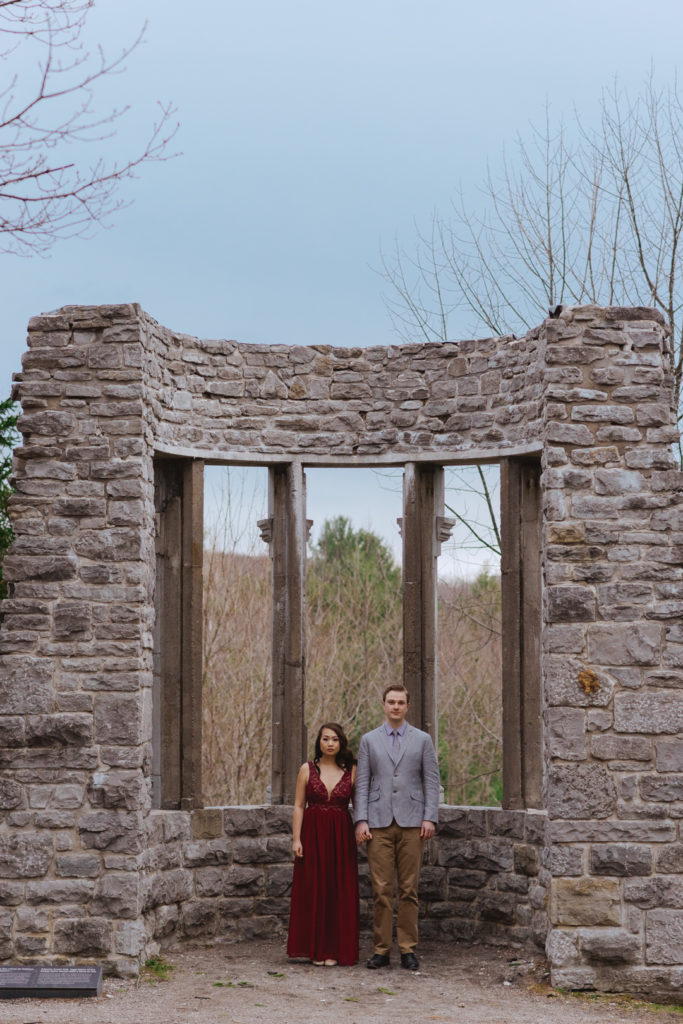 engaged couple standing among the ruins