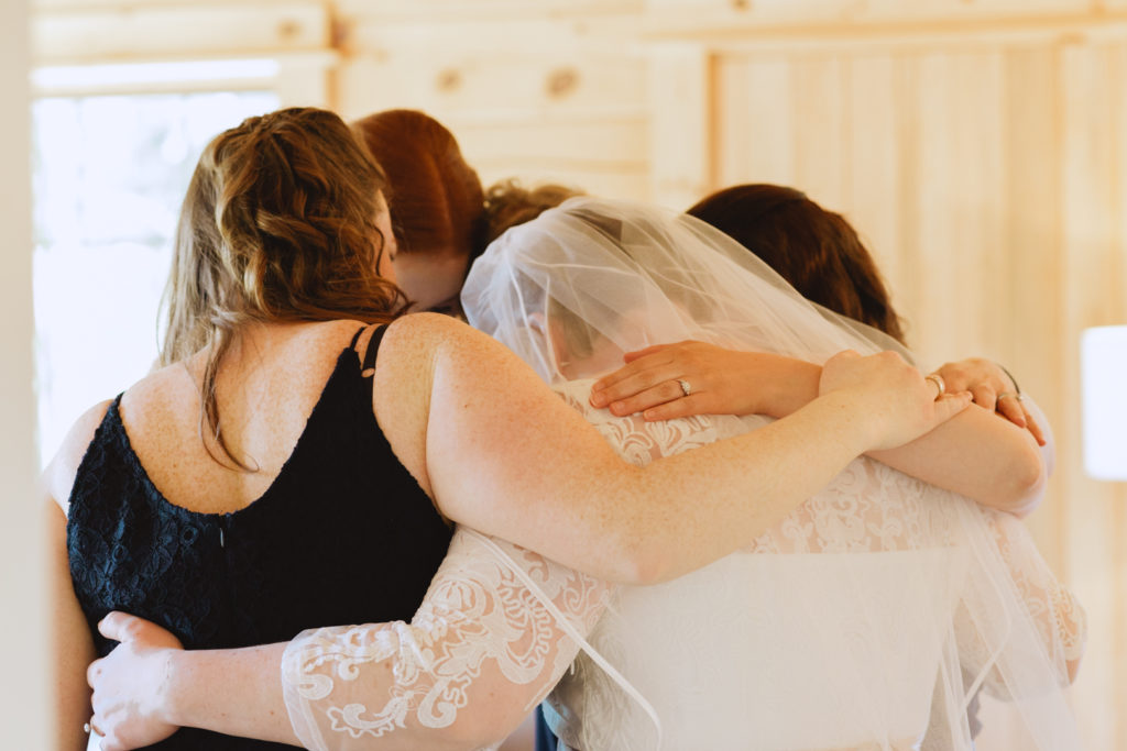bride hugging her bridesmaids before the first look