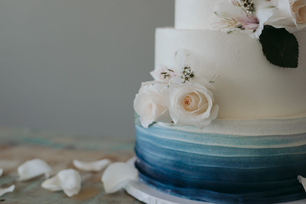 beautiful wedding cake by Thimble Cakes on top of an antique table