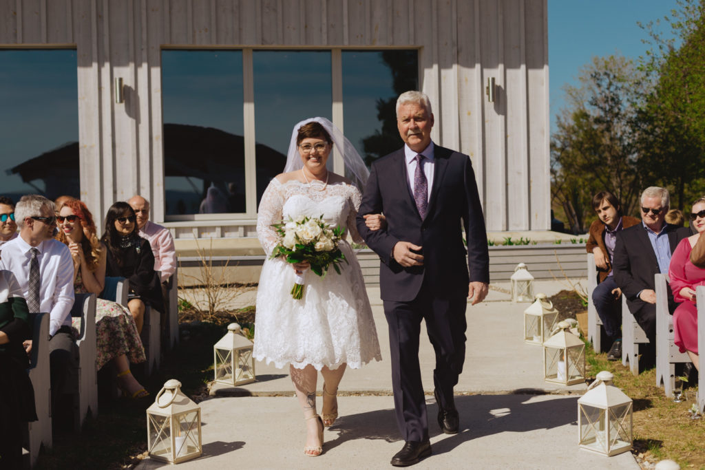 bride and her father walking down the aisle at outdoor ceremony