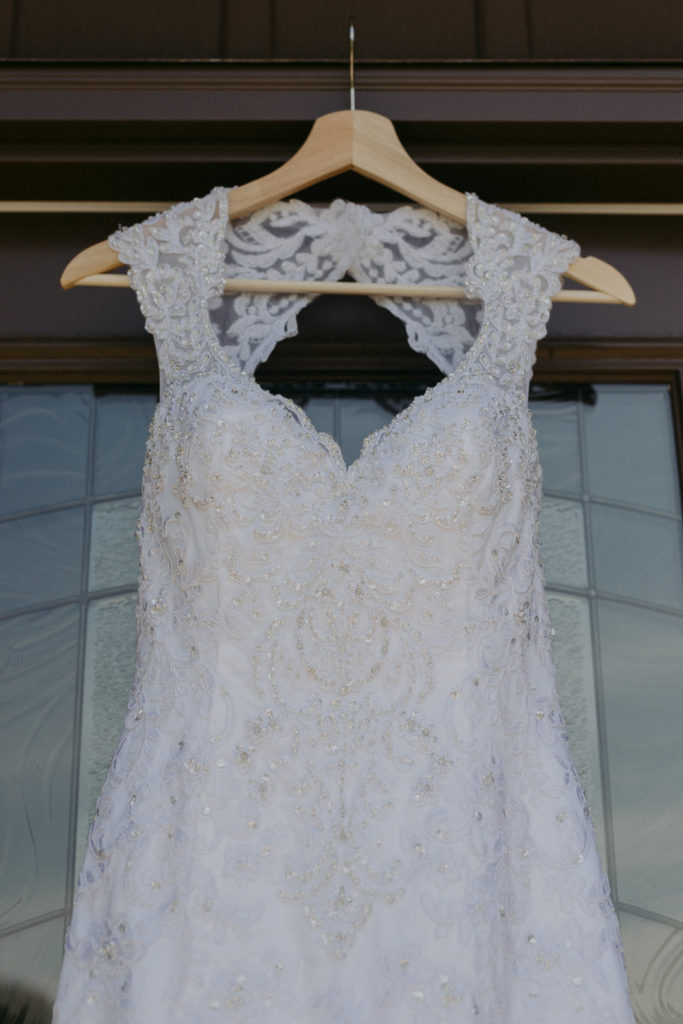 wedding dress hanging from wooden hanger