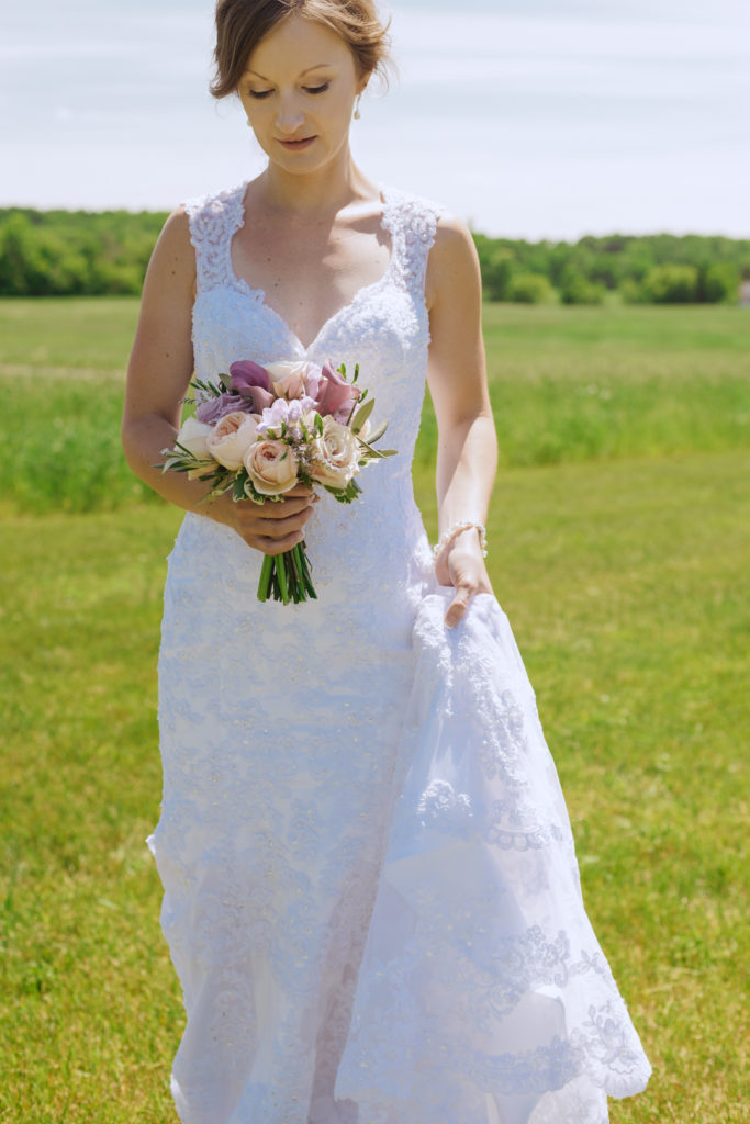bride holding her train and bouquet