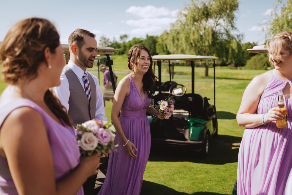 wedding party hanging out by the golf carts