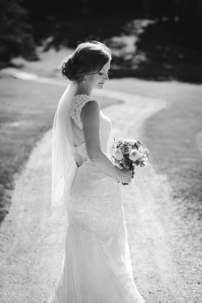 bride in black and white standing on dirt path