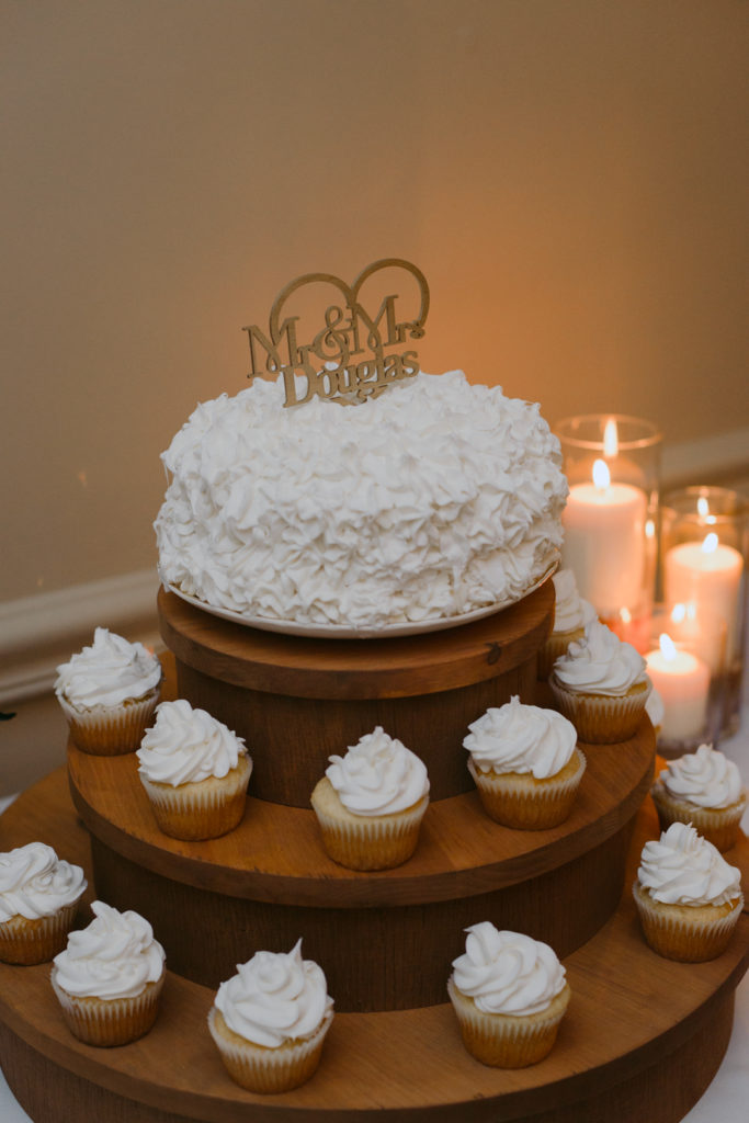 white wedding cake and cupcake with gold cake topper