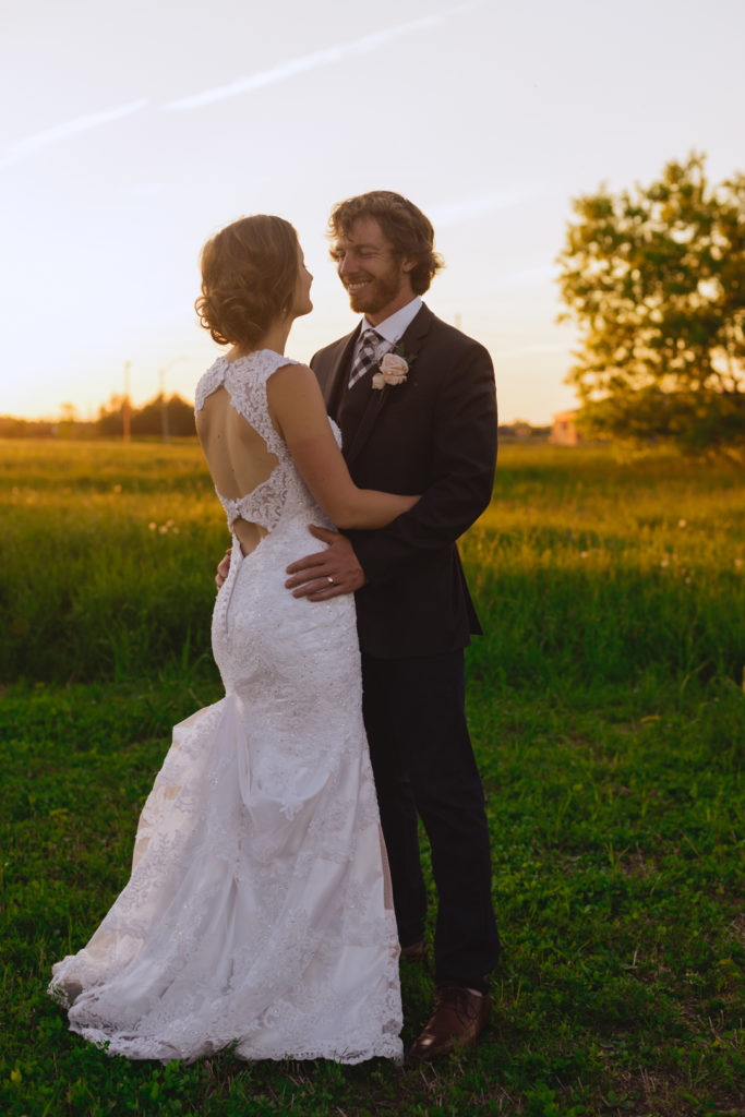 bride and groom at sunset in field