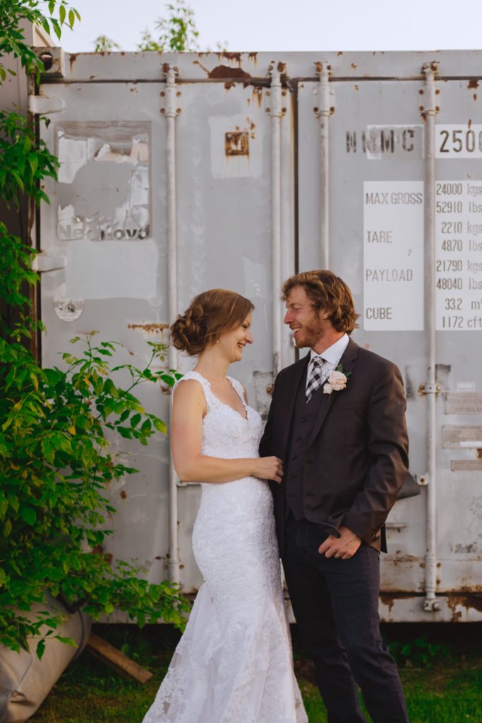 bride and groom in front of shipping container