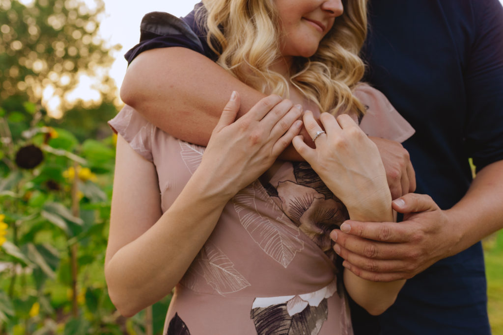 engaged couple wrapping their arms around each other