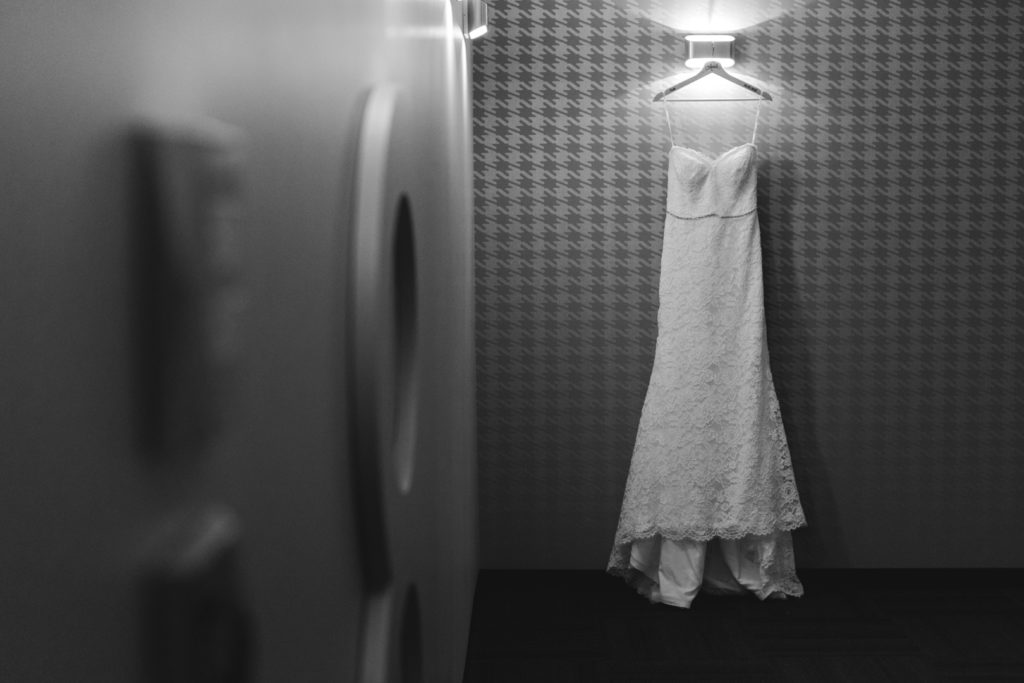 dress hanging from light in hotel hallway
